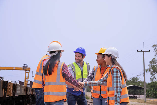Adobe Stock image of five engineers shaking hands.